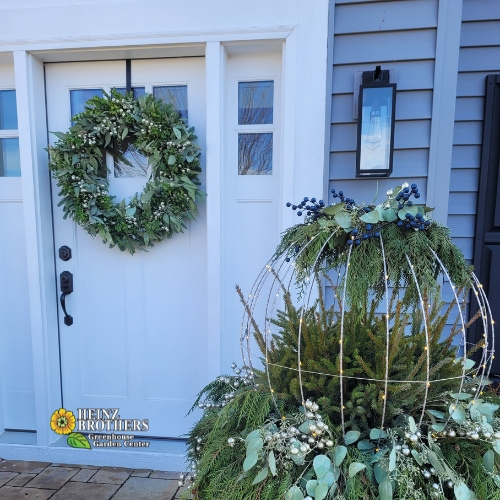 White front door of a home with a holiday wreath on it