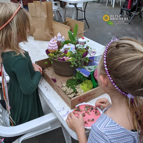 Two girls building atriums inside of the garden center at Heinz Brothers