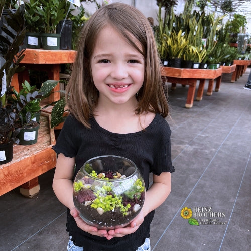 A girl posing with an atrium she made inside of the garden center at Heinz Brothers