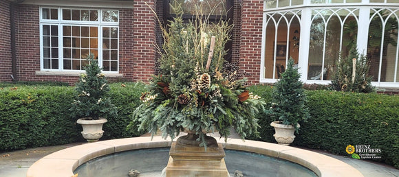 custom container with greenery, pinecones and glitter sticks at private estate