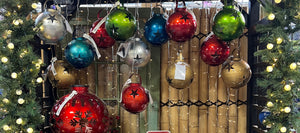 hanging metal solar ornaments in red, green, gold, blue and silver with star and snowflake cutouts 