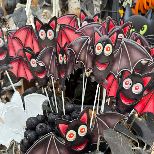 Chocolate bat decorative picks with red and black colors, surrounded by Halloween decorations.