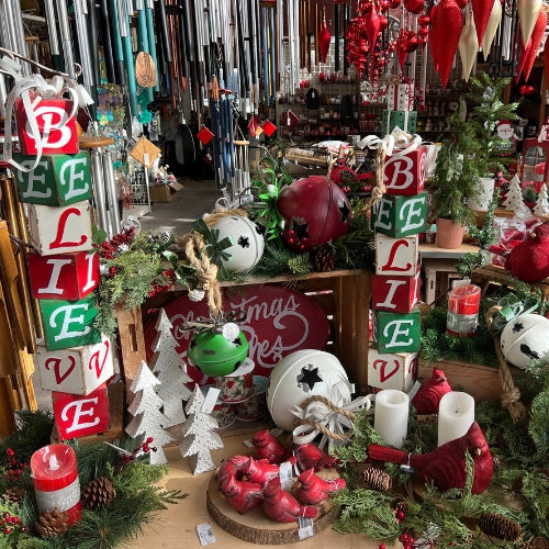 red, white and green metal holiday decorations, believe present statue, large metal sleigh bells, red and white christmas wishes sign