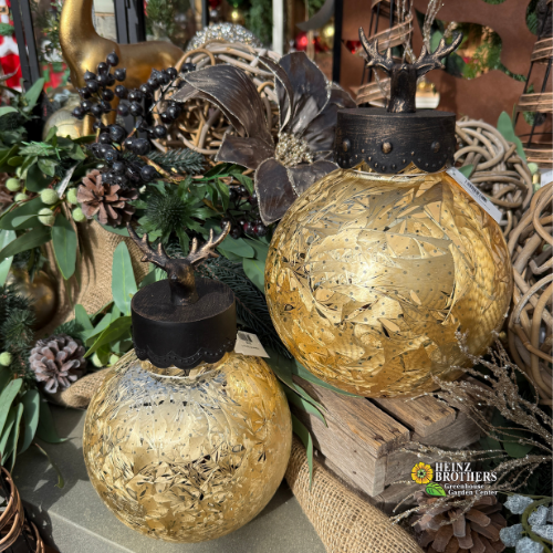 Decorative gold ornament lanterns with bronze-look deer tops on a rustic background garland background.