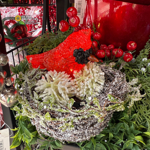 Decorative snow nest with lighted cardinal ornament on display in garland