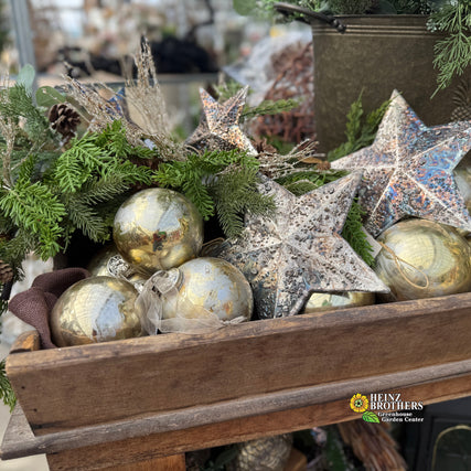 Seasonal Design inspiration at Heinz!Decorative arrangement with metallic balls and stars in a wooden box, Heinz Brothers Garden Center logo visible.